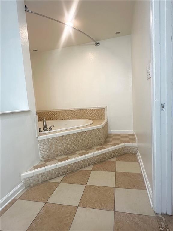 bathroom featuring tile patterned floors and tiled tub