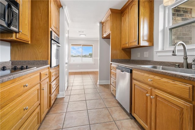 kitchen featuring appliances with stainless steel finishes, light tile patterned floors, and sink