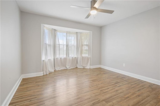 spare room with ceiling fan and light wood-type flooring