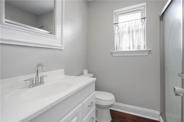 bathroom with hardwood / wood-style flooring, vanity, an enclosed shower, and toilet