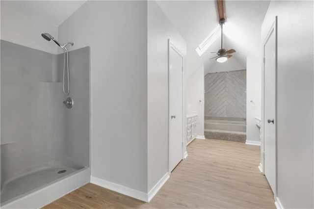 bathroom with hardwood / wood-style floors, ceiling fan, lofted ceiling, and walk in shower