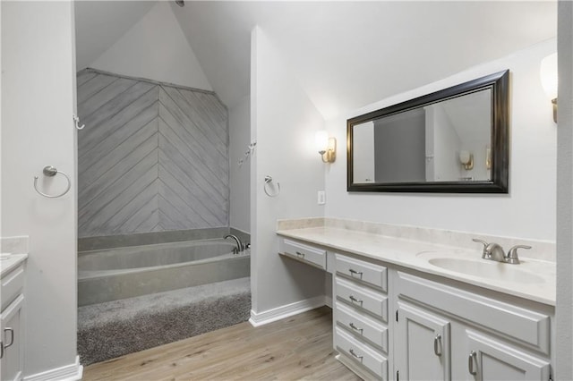 bathroom with vanity, lofted ceiling, and hardwood / wood-style flooring