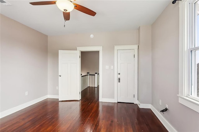 empty room featuring ceiling fan and dark wood-type flooring