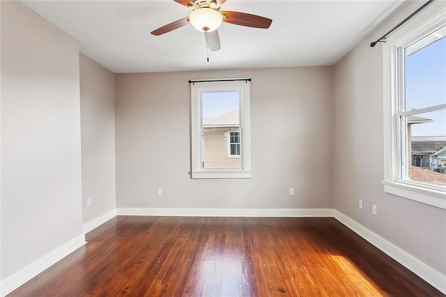 empty room with dark hardwood / wood-style floors, ceiling fan, and a healthy amount of sunlight