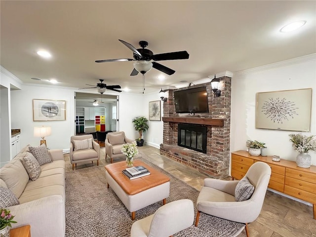 living room featuring ceiling fan, light wood-type flooring, ornamental molding, and a fireplace