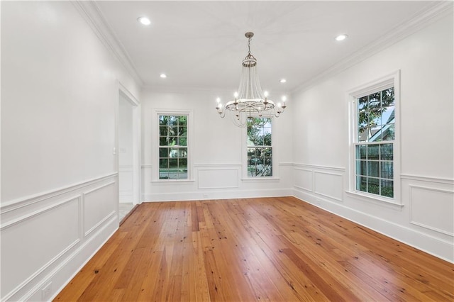 unfurnished dining area featuring hardwood / wood-style floors, a healthy amount of sunlight, and ornamental molding