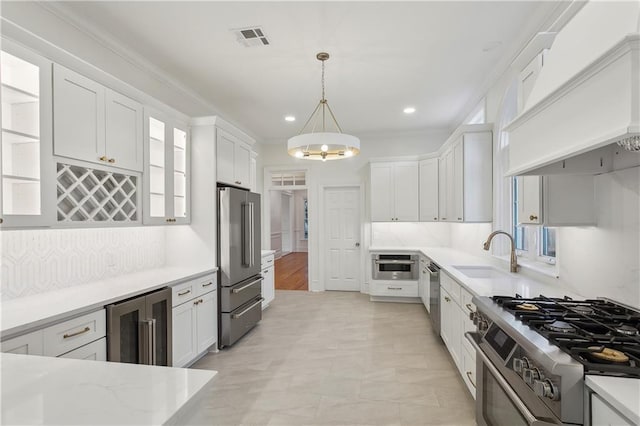 kitchen featuring sink, white cabinets, beverage cooler, and premium appliances