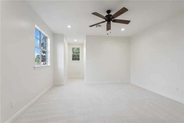 spare room with ceiling fan and light colored carpet