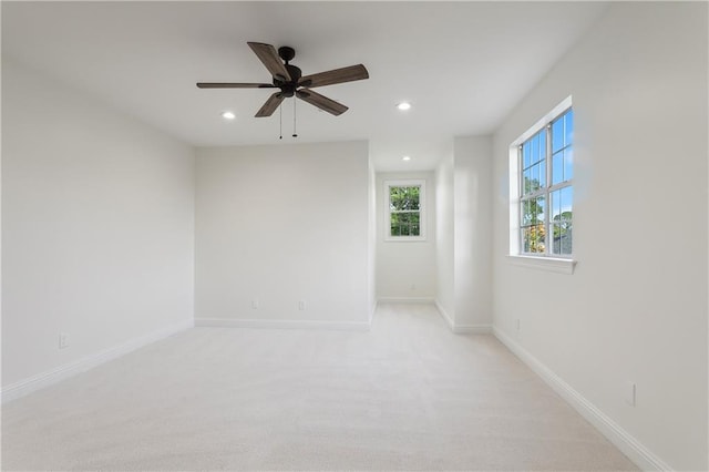 unfurnished room with ceiling fan and light carpet