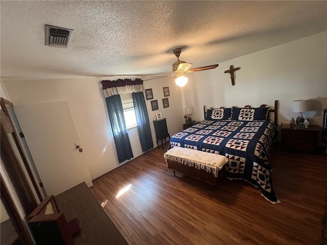 bedroom with ceiling fan, dark hardwood / wood-style flooring, and a textured ceiling