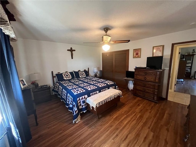 bedroom featuring a closet, dark hardwood / wood-style floors, and ceiling fan