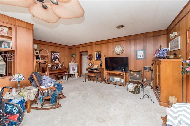 carpeted living room featuring wooden walls