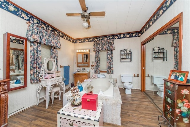 bathroom featuring hardwood / wood-style floors, ceiling fan, toilet, and a tub