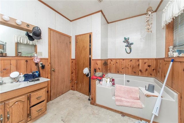 bathroom featuring a tub, crown molding, wooden walls, and vanity