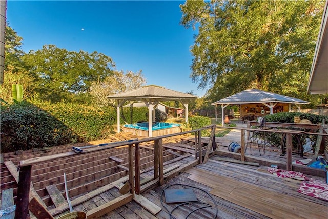 view of dock with a gazebo, a hot tub, and a deck