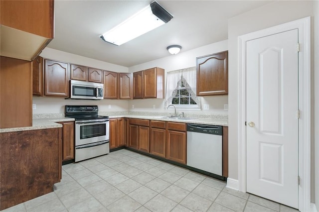 kitchen featuring light tile patterned flooring, stainless steel appliances, and sink