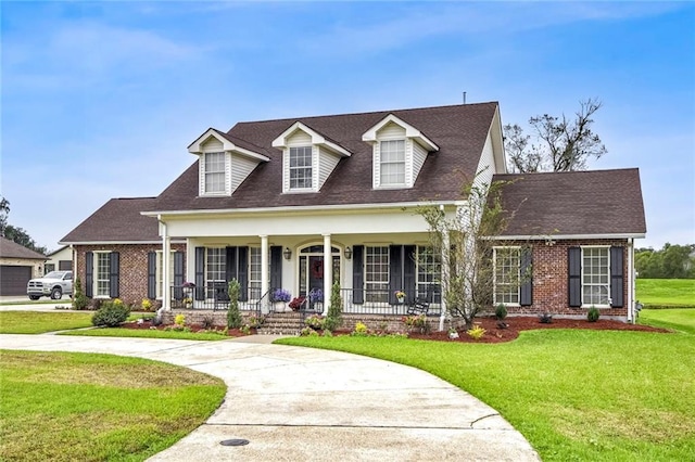 cape cod-style house featuring a front yard and a porch