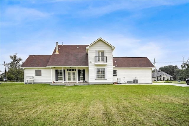 back of house with cooling unit, a balcony, a yard, and french doors