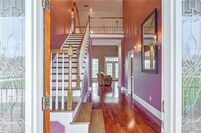 foyer entrance featuring dark hardwood / wood-style flooring and a high ceiling