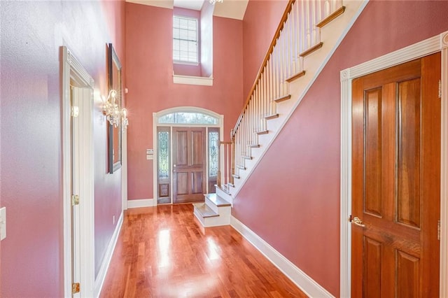 entrance foyer featuring a high ceiling, light wood-type flooring, and plenty of natural light