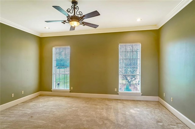 carpeted spare room featuring crown molding, plenty of natural light, and ceiling fan