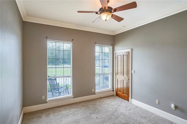 spare room featuring light carpet, ceiling fan, and crown molding