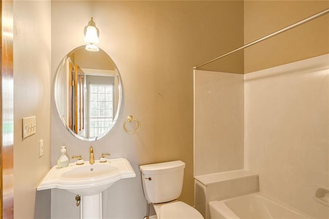 bathroom featuring toilet and a tub to relax in