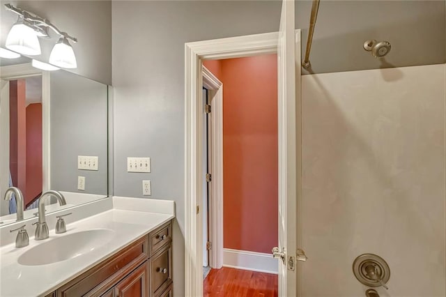 bathroom with hardwood / wood-style floors, vanity, and shower / bathing tub combination