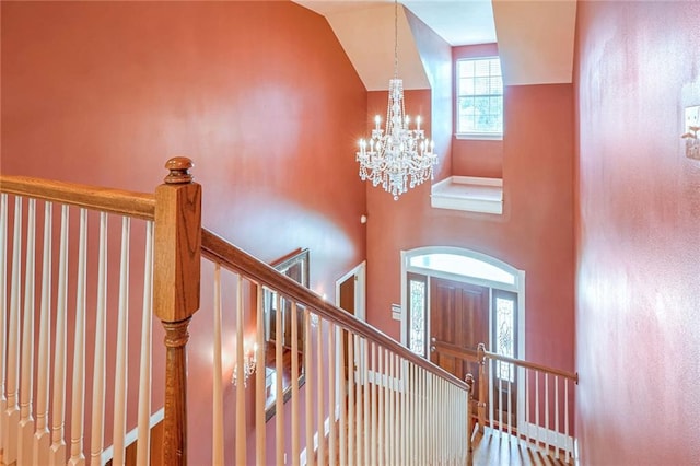 stairway with a towering ceiling and an inviting chandelier