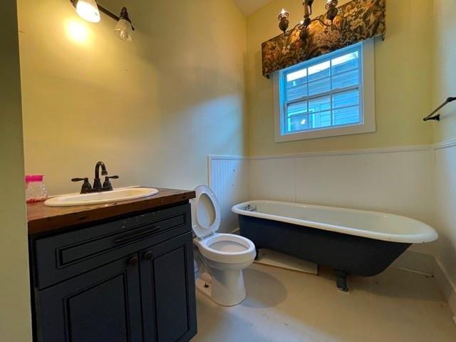 bathroom with vanity, a tub to relax in, and toilet