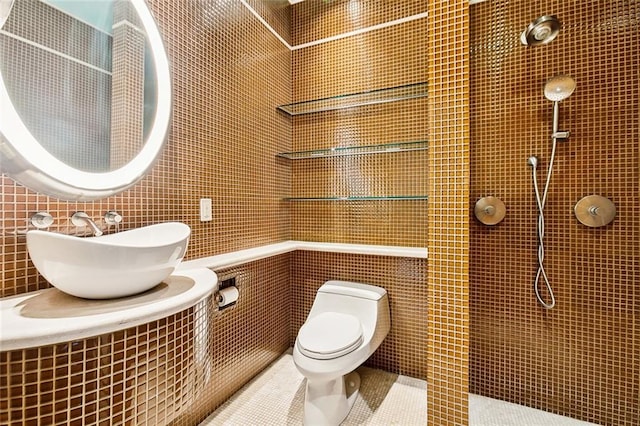 bathroom with tile patterned floors, toilet, tile walls, and sink