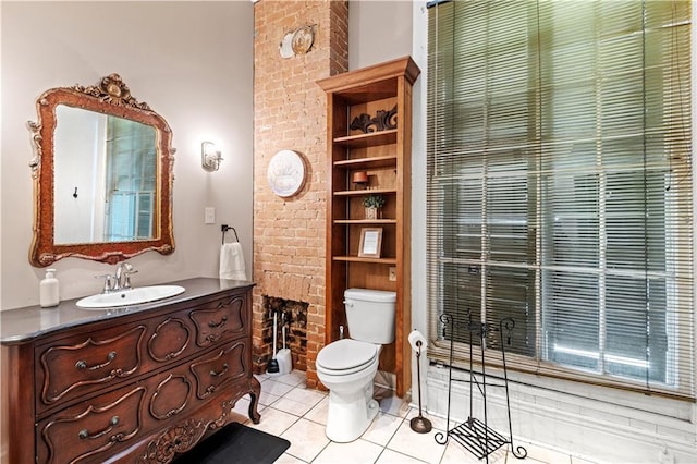 bathroom featuring tile patterned flooring, a brick fireplace, toilet, and brick wall