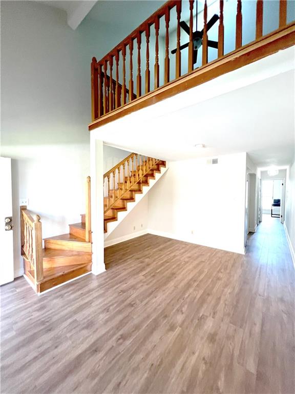 unfurnished living room with a high ceiling and hardwood / wood-style flooring