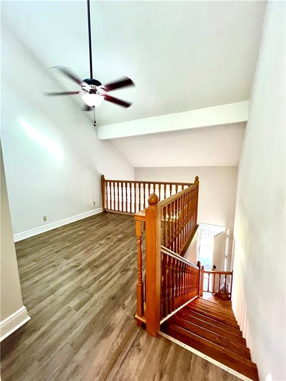 staircase featuring hardwood / wood-style flooring, vaulted ceiling, and ceiling fan