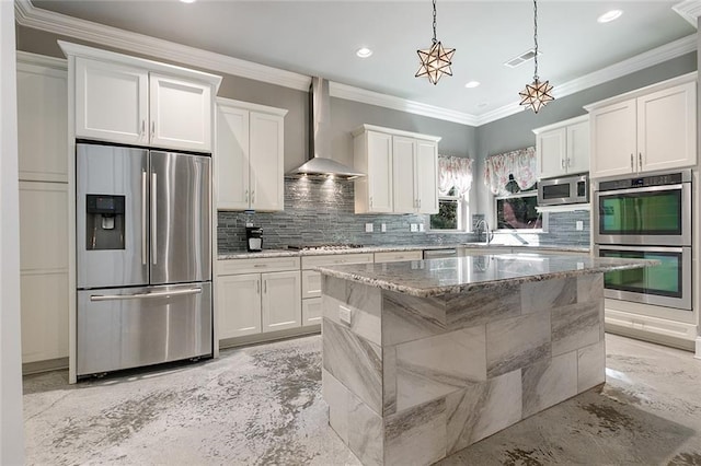 kitchen with white cabinets, wall chimney exhaust hood, and appliances with stainless steel finishes