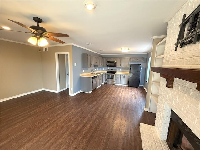 kitchen with ceiling fan, a brick fireplace, dark hardwood / wood-style flooring, black appliances, and ornamental molding