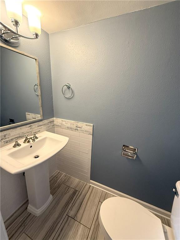 bathroom with tile walls and toilet