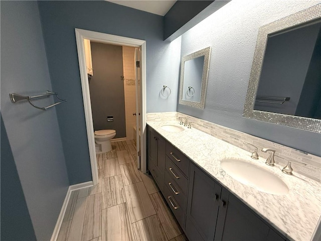 bathroom with decorative backsplash, vanity, and toilet