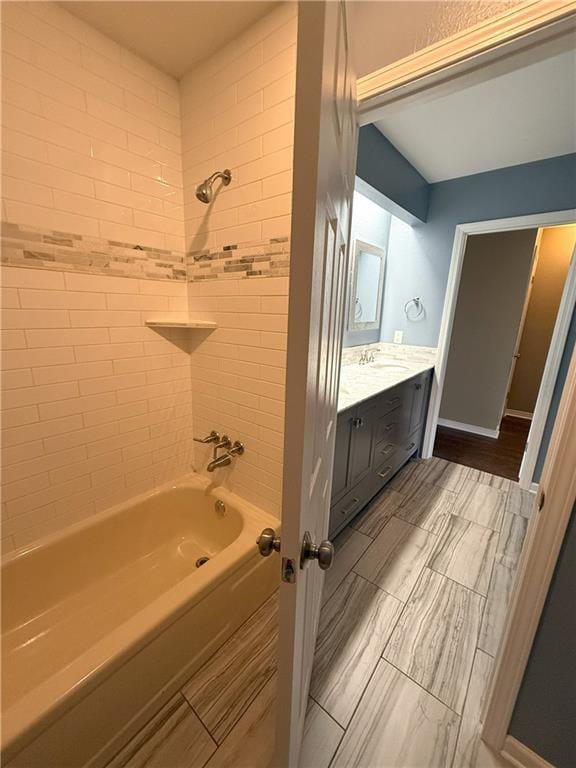 bathroom with tiled shower / bath combo and vanity