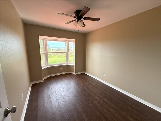 spare room with ceiling fan and dark hardwood / wood-style floors