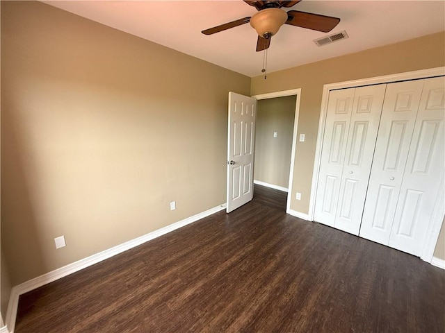 unfurnished bedroom with dark hardwood / wood-style flooring, a closet, and ceiling fan