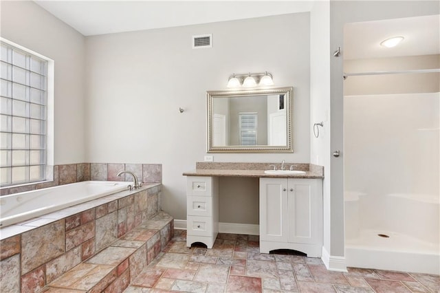 bathroom featuring vanity and a relaxing tiled tub