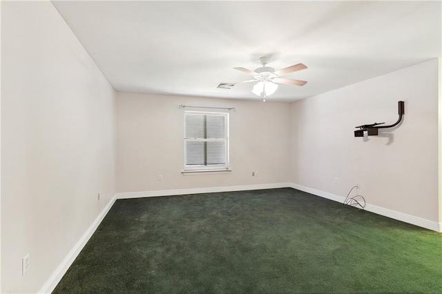 spare room featuring ceiling fan and dark colored carpet