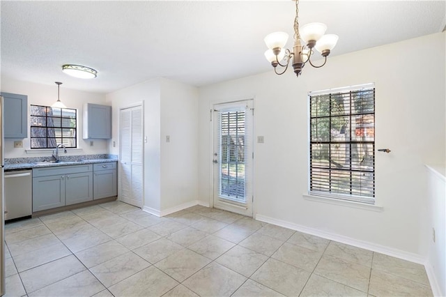 kitchen featuring dishwasher, an inviting chandelier, pendant lighting, and sink