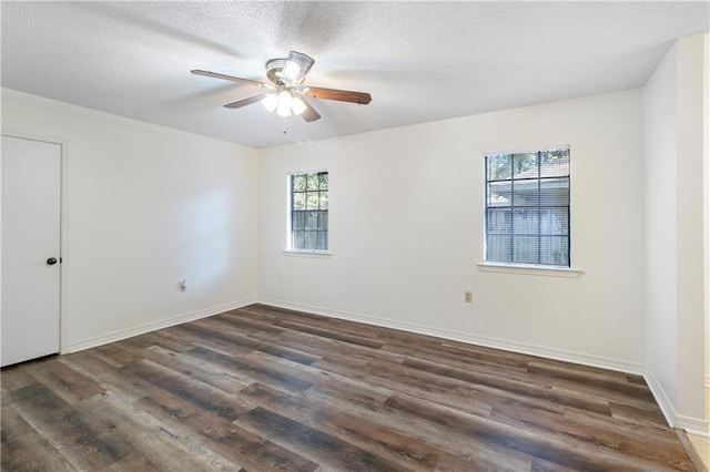 empty room with ceiling fan, dark wood-type flooring, and a textured ceiling