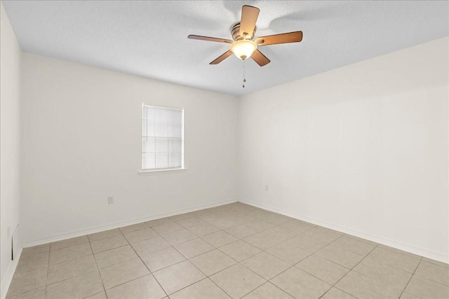 tiled empty room featuring ceiling fan