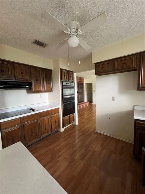 kitchen with ceiling fan, dark hardwood / wood-style flooring, a textured ceiling, dark brown cabinets, and black appliances