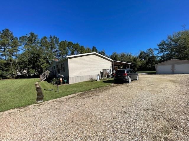 view of side of home featuring a garage, a lawn, and an outdoor structure