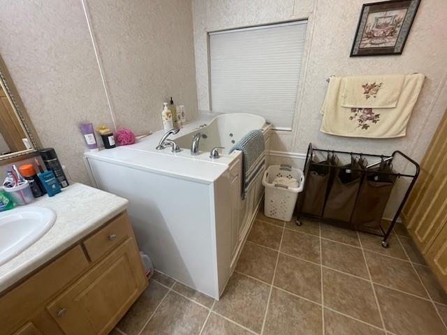 bathroom featuring tile patterned flooring, vanity, a shower with shower door, and a textured ceiling