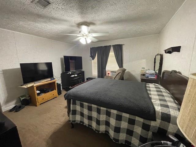 bedroom with carpet floors, visible vents, ceiling fan, and a textured ceiling